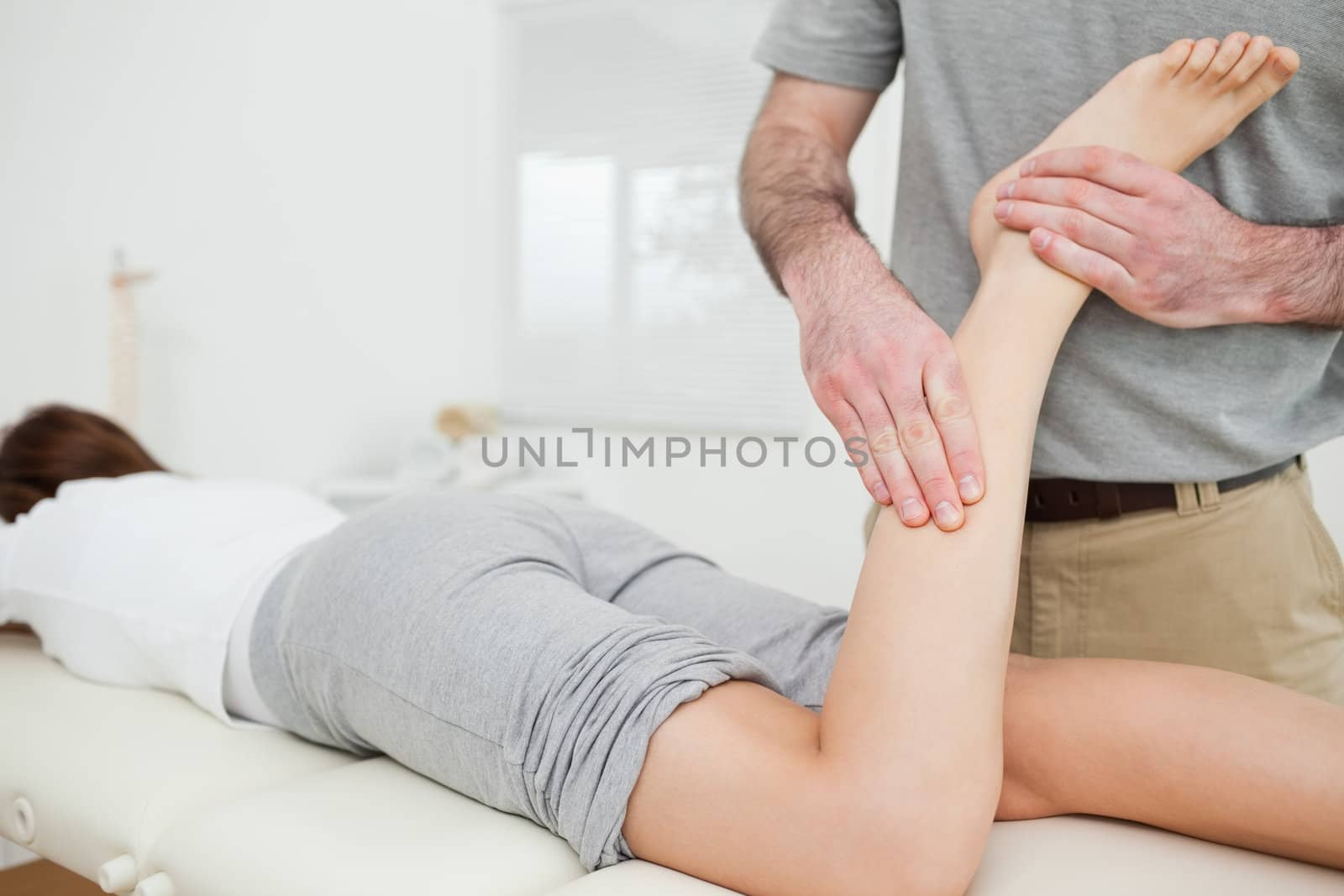 Woman lying while a doctor is examining her leg by Wavebreakmedia