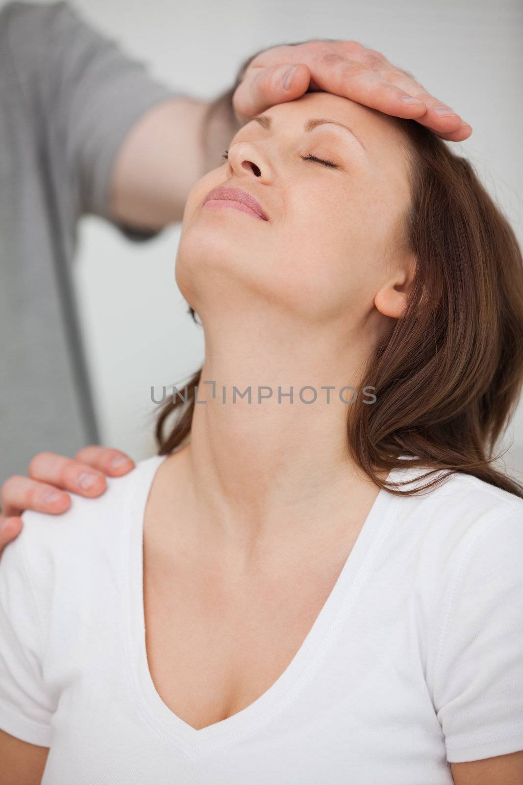 Doctor posing his hand on the forehead of a patient by Wavebreakmedia