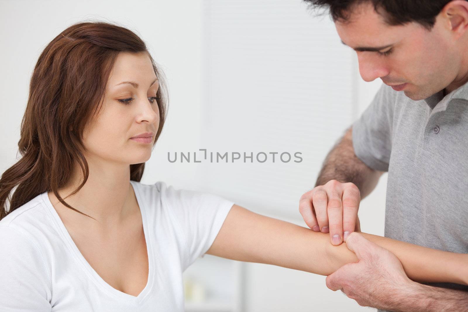 Doctor examining the arm of a patient in a room