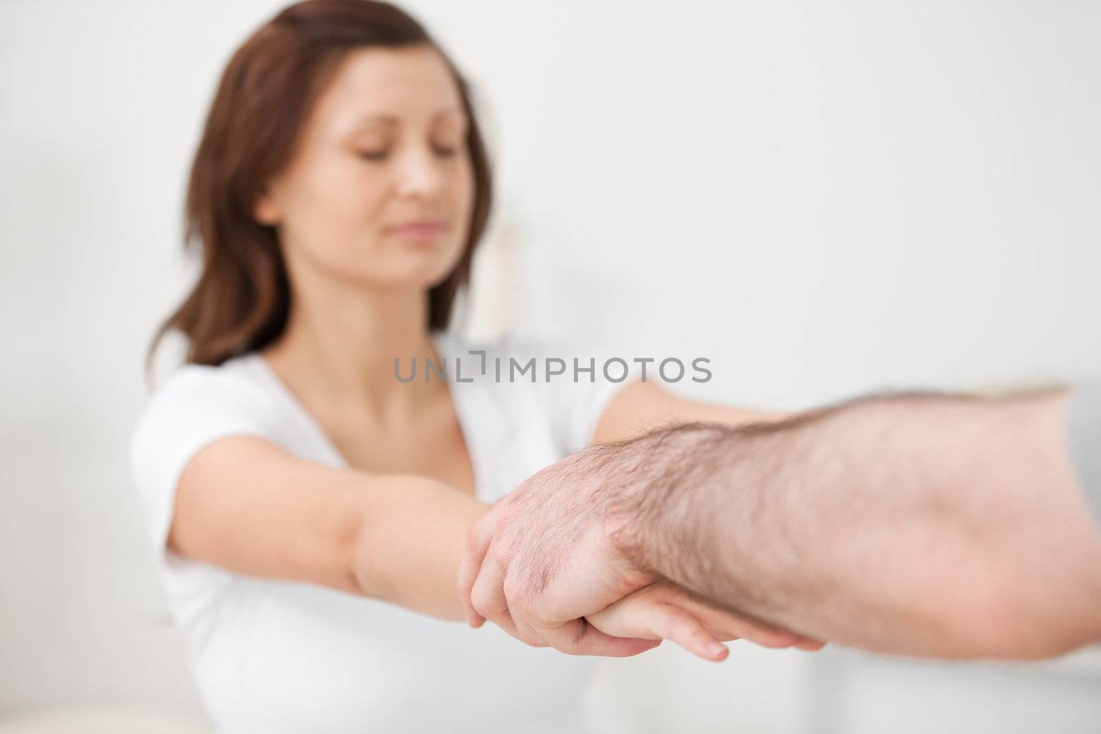 Practitioner extending the arms of a patient in a room