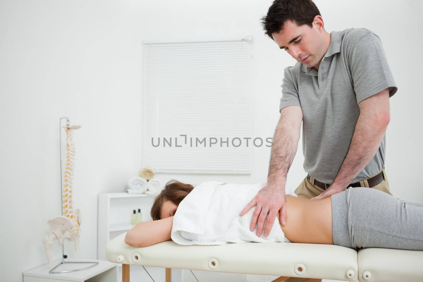Brown-haired doctor massaging the back of a woman by Wavebreakmedia