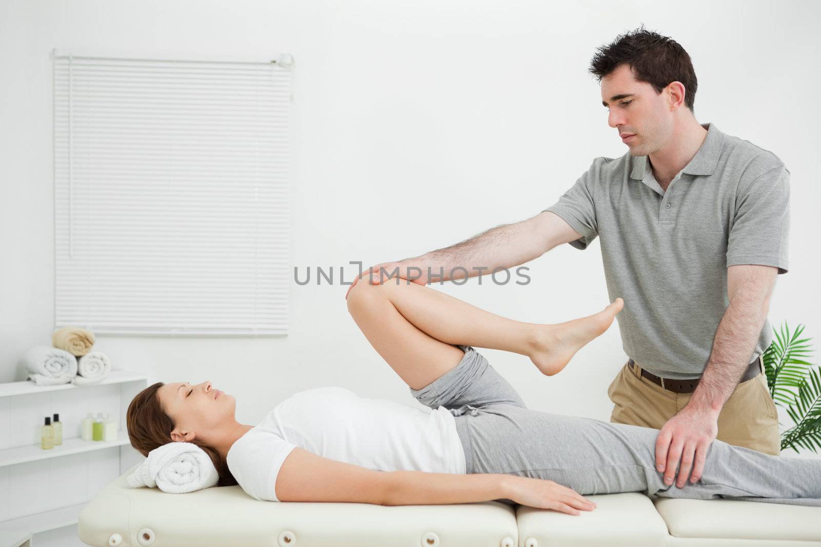 Woman lying on her back while being stretched in a room