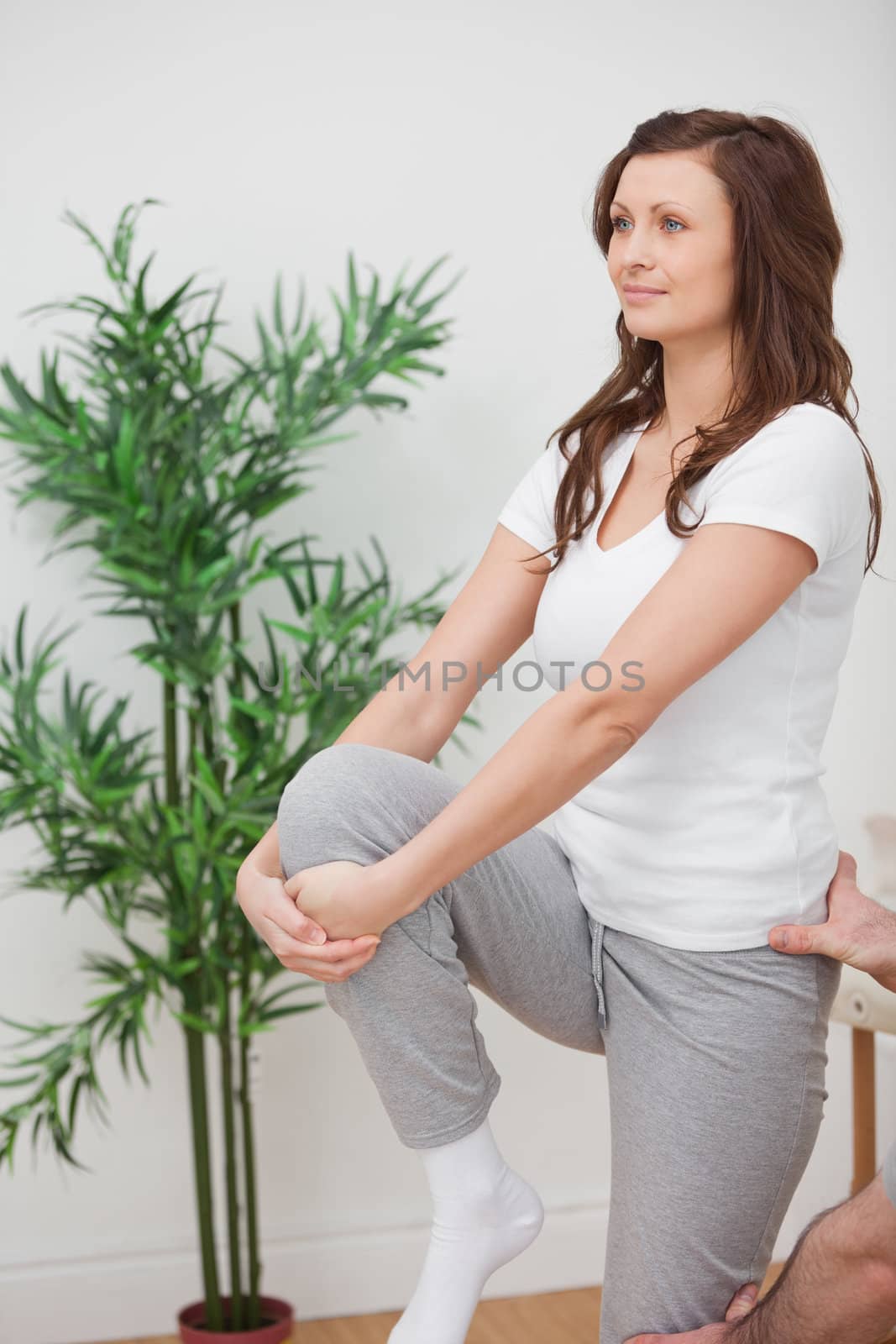 Woman standing while stretching her leg in a room