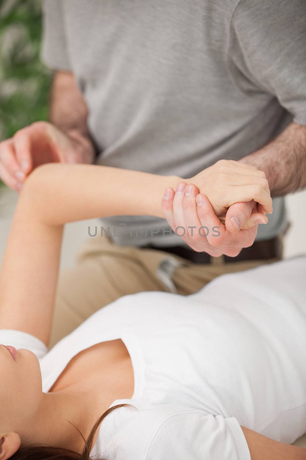 Physiotherapist moving the arm of a woman by Wavebreakmedia