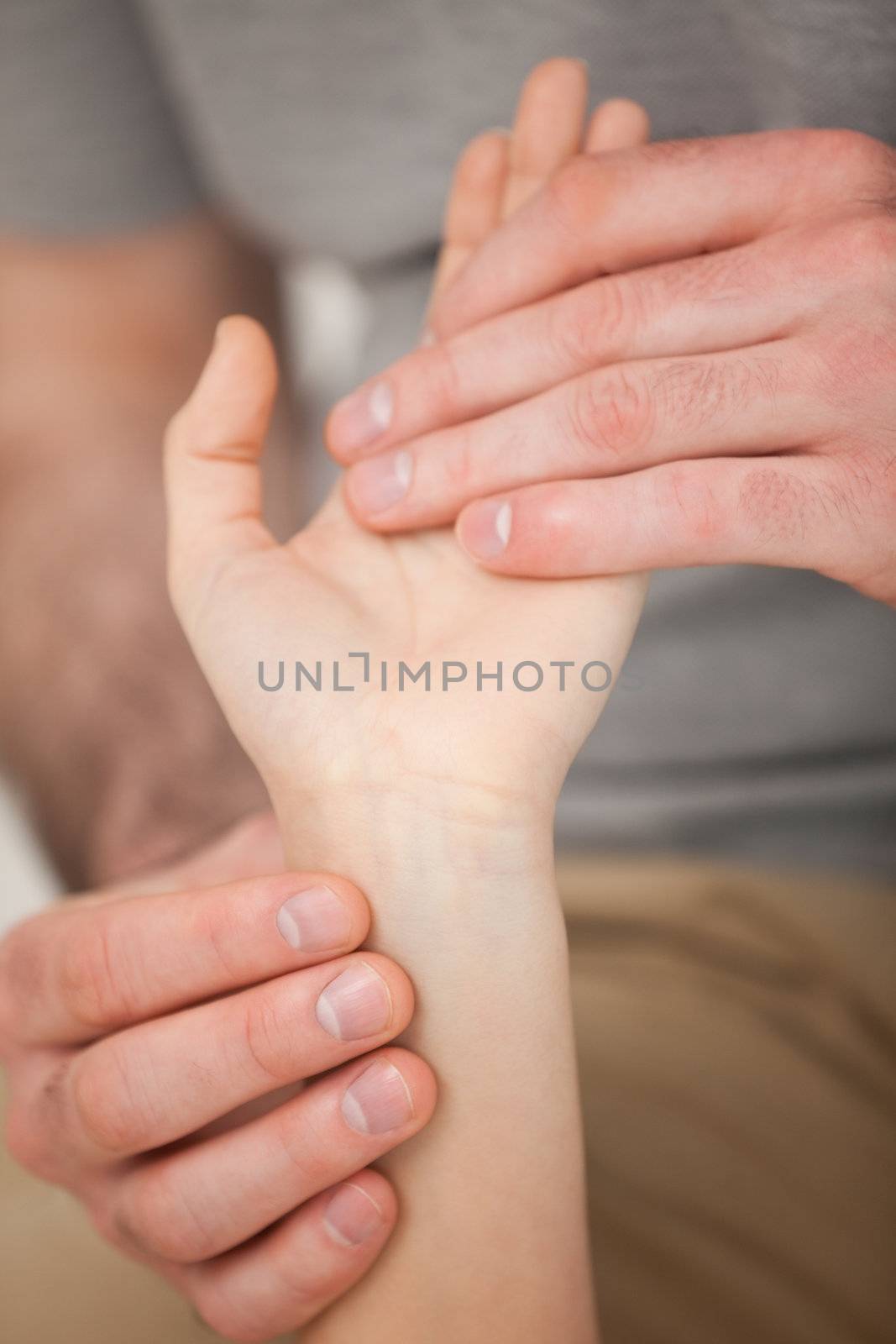 Doctor looking at the wrist of a patient by Wavebreakmedia