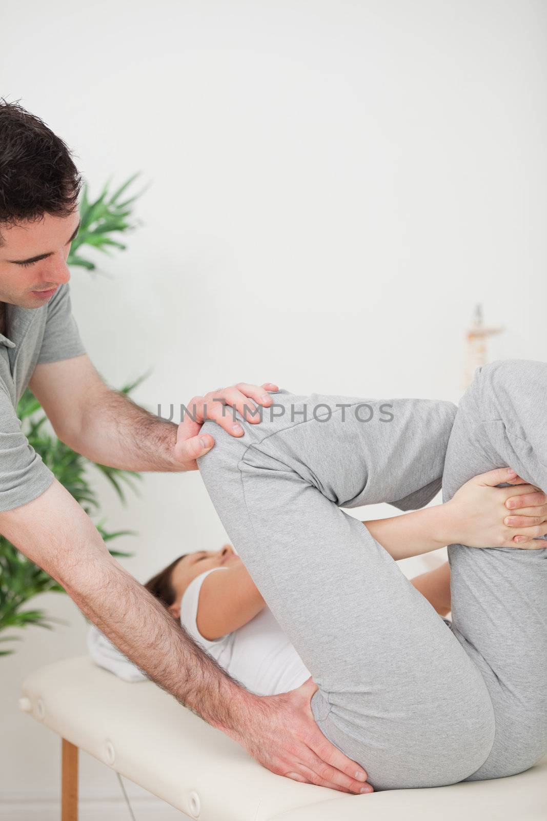 Close-up of a physiotherapist helping a woman for her exercise in a room