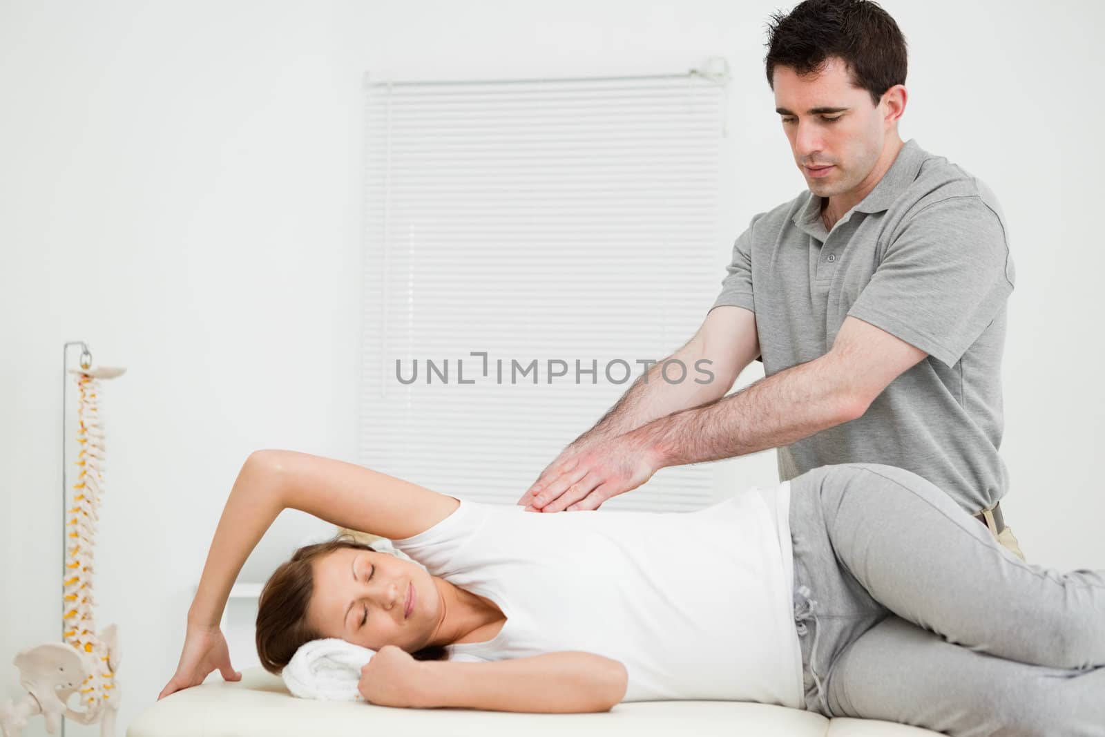 Serious doctor using his fingertips on a patient in a bright room