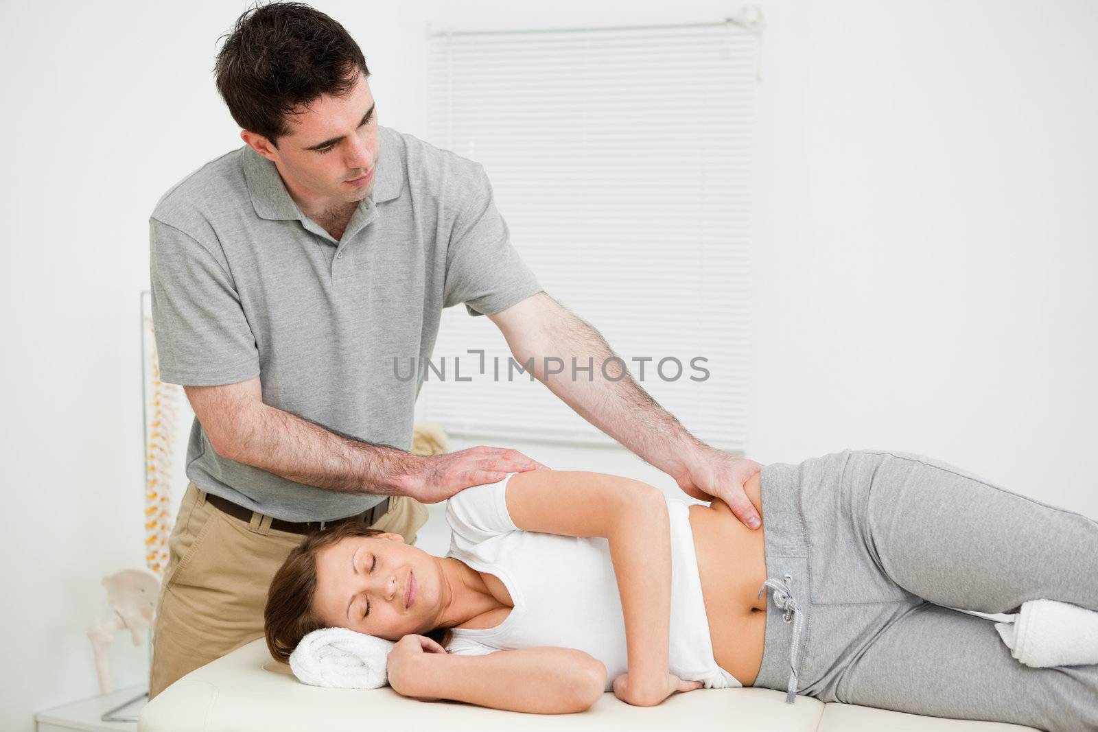 Serious practitioner massaging a peaceful woman by Wavebreakmedia
