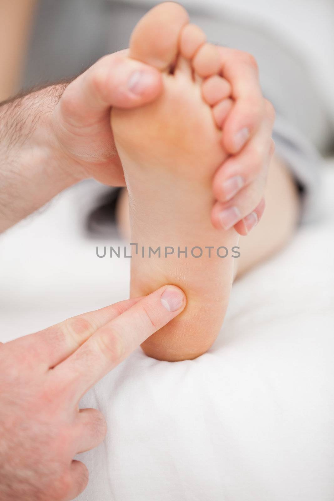 Doctor massaging the ball of the foot in a room