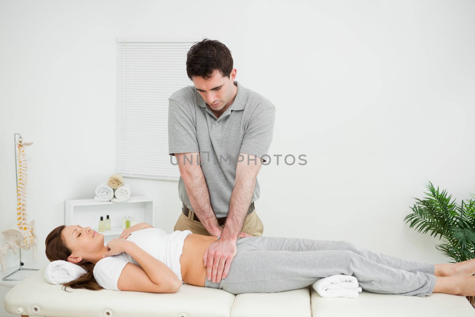 Peaceful woman being touched by an osteopath in his medical room