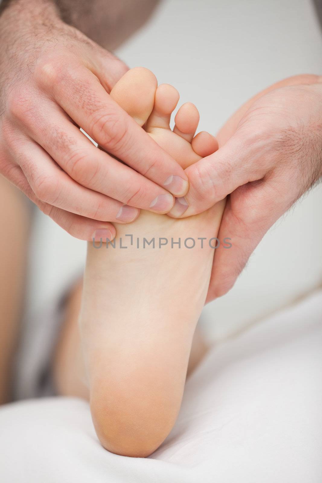 Foot being touched by a chiropodist in a room