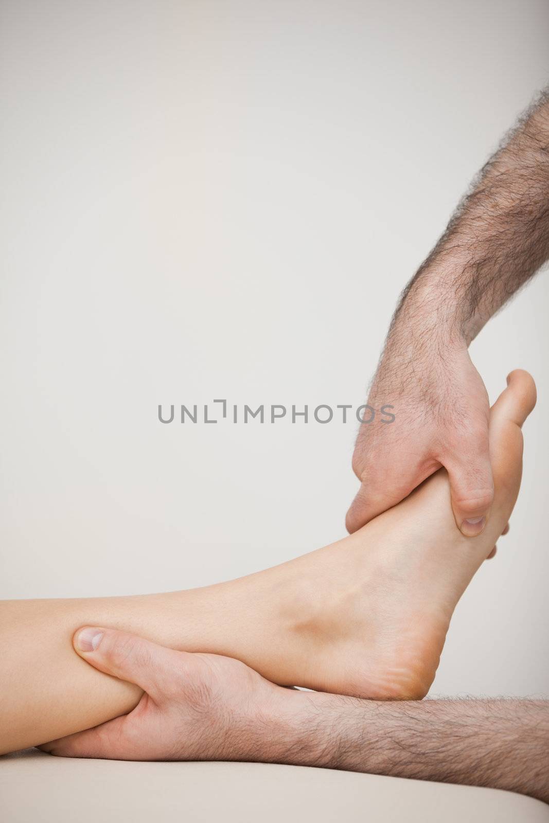 Side view of a foot being touched by a doctor in a room