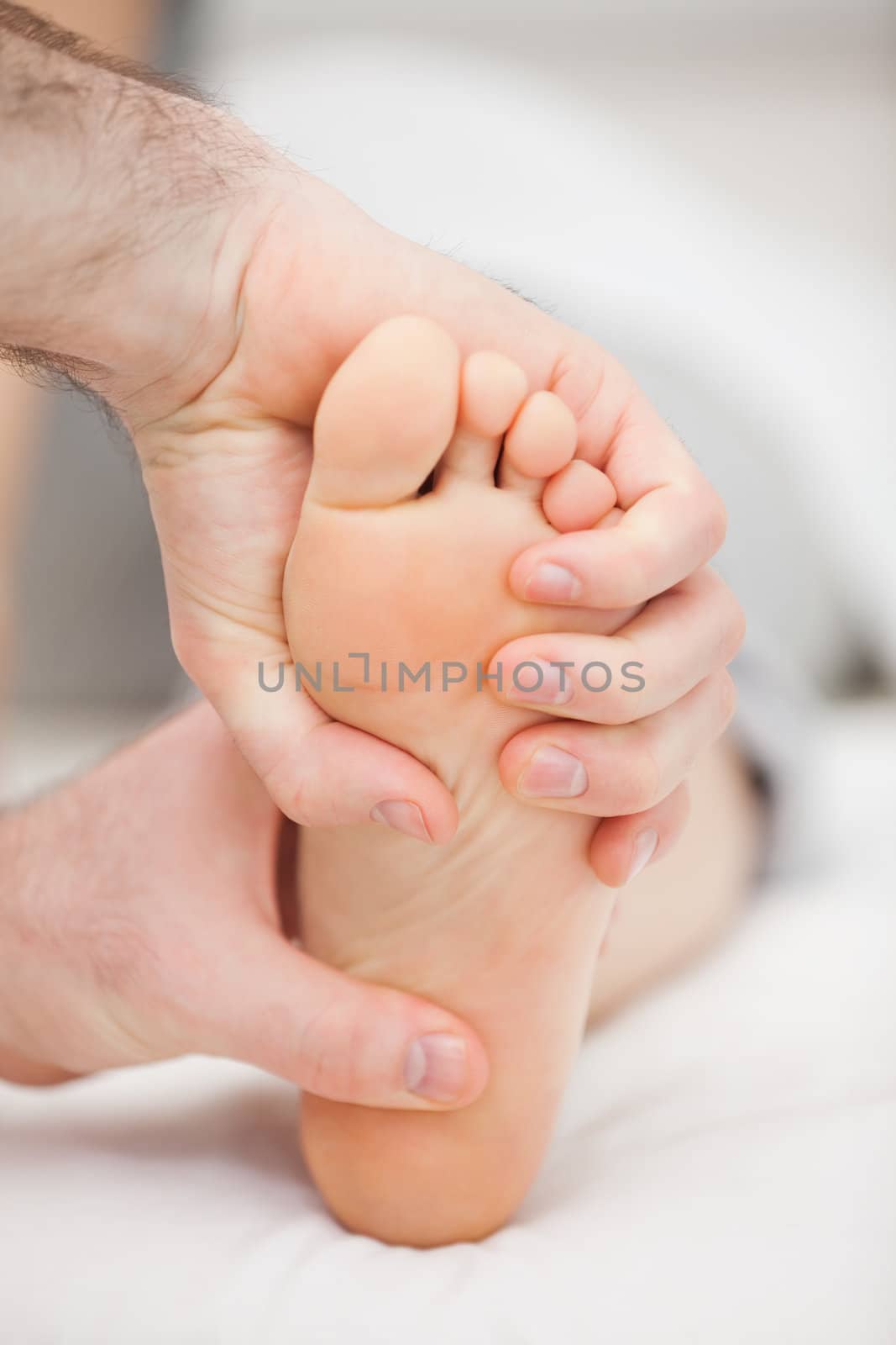 Foot being held by two hands in a medical room