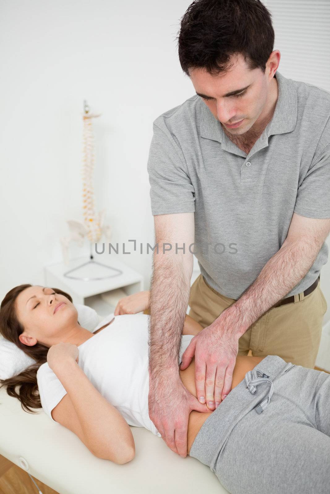 Brunette woman having a stomach ache while lying in a room