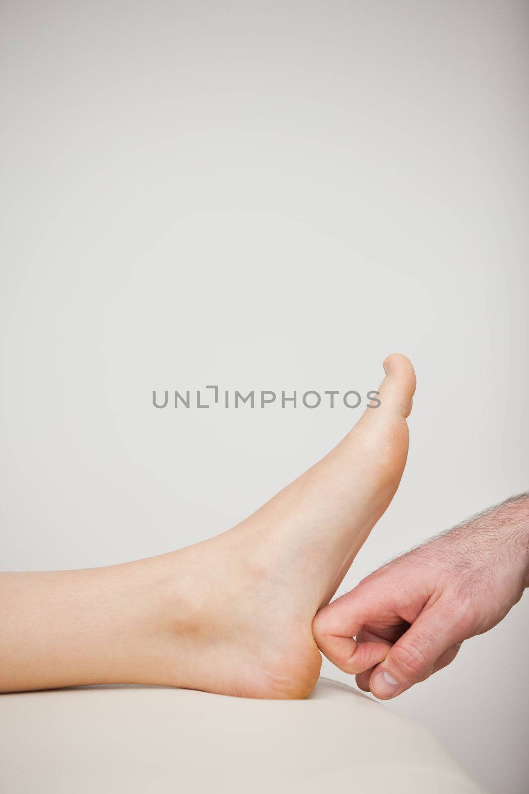Doctor putting his forefinger on a barefoot by Wavebreakmedia