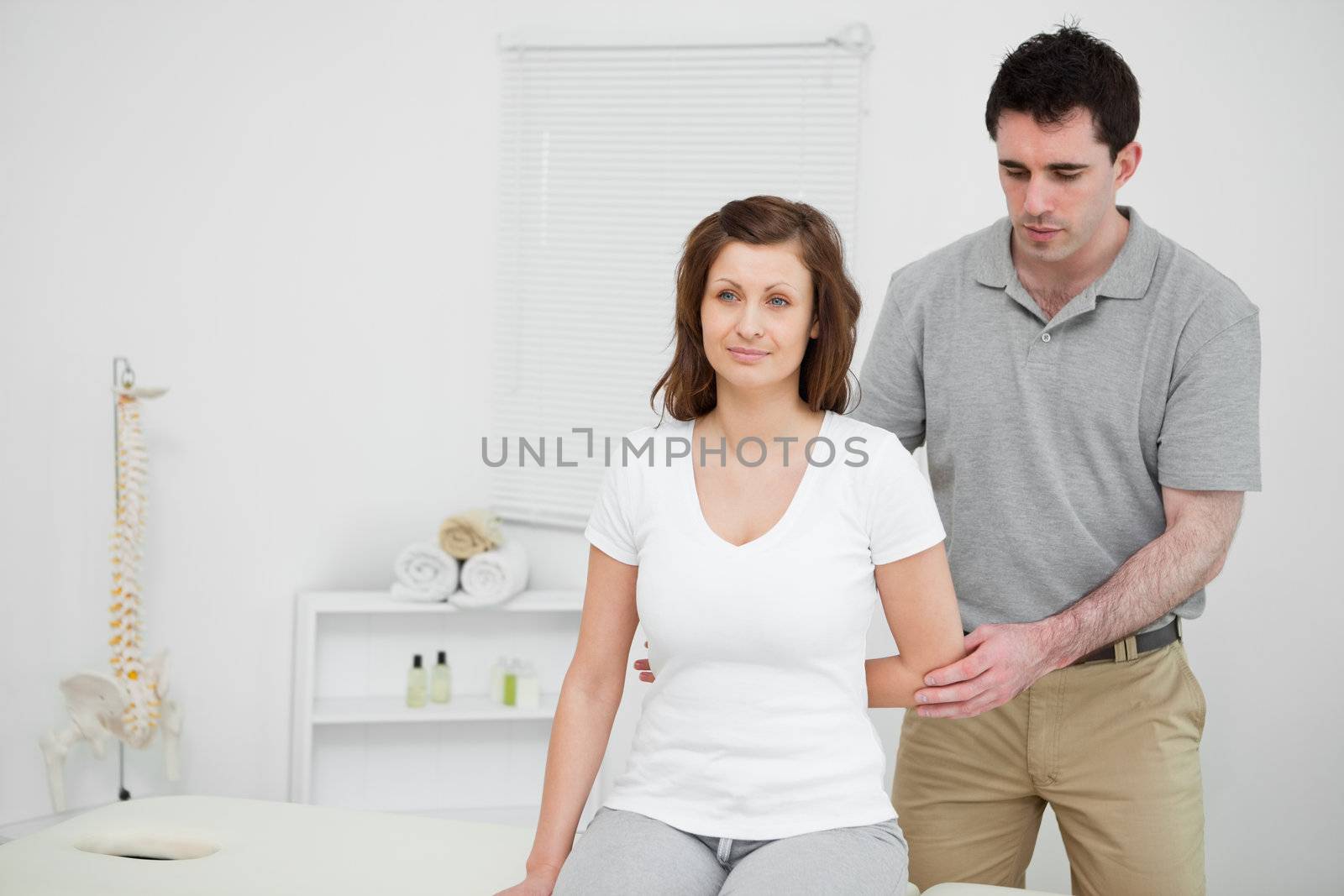 Serious practitioner holding the elbow of a patient by Wavebreakmedia