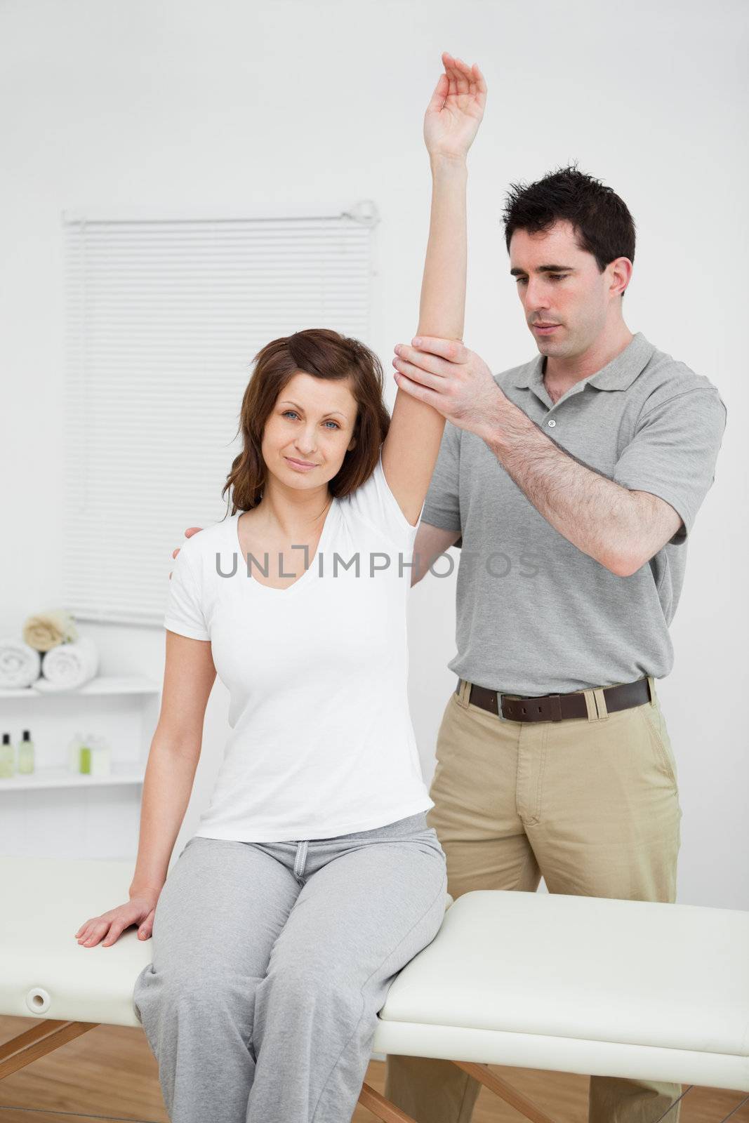 Peaceful woman keeping her arm up in a medical room
