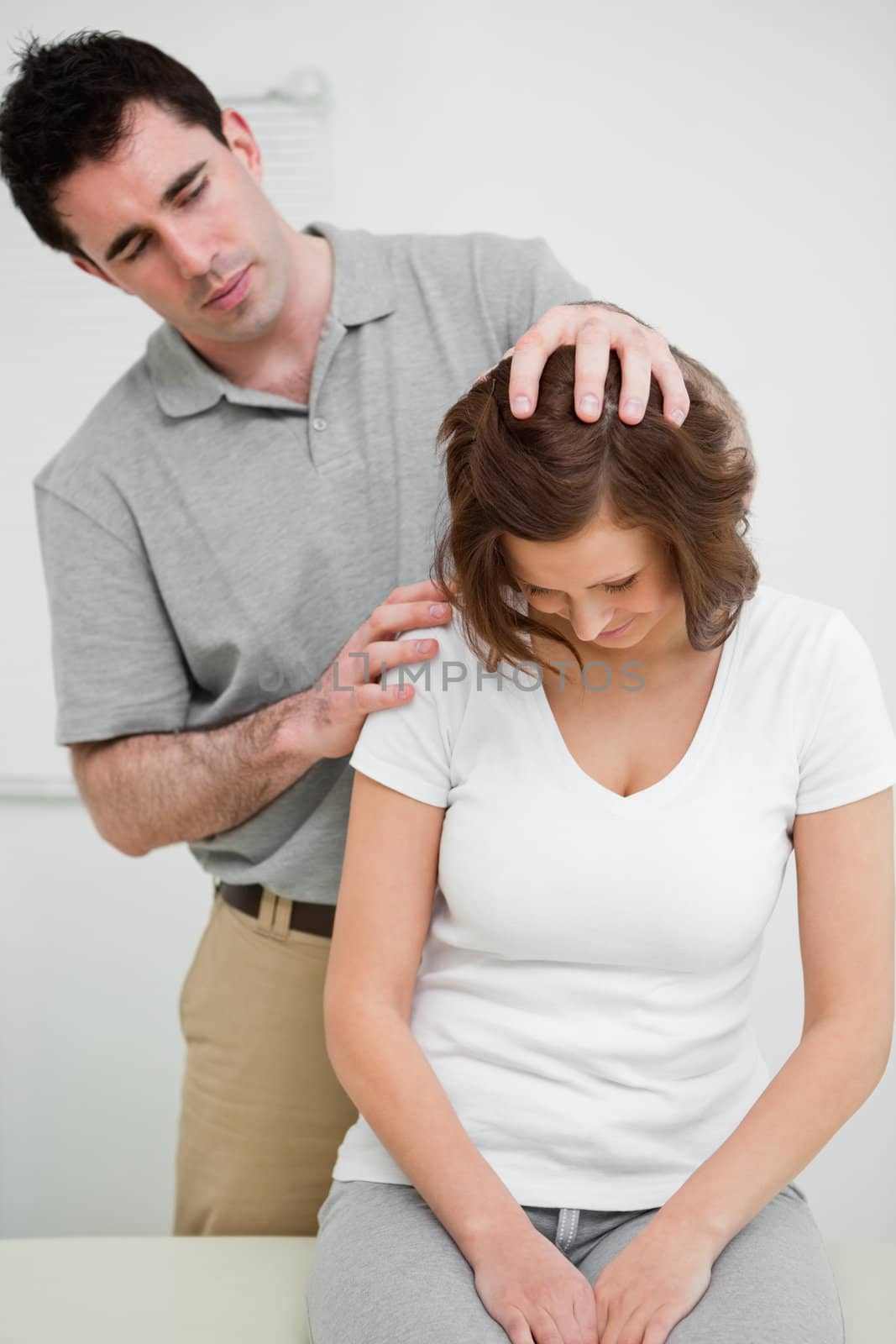 Physiotherapist moving the head of a patient in a medical room