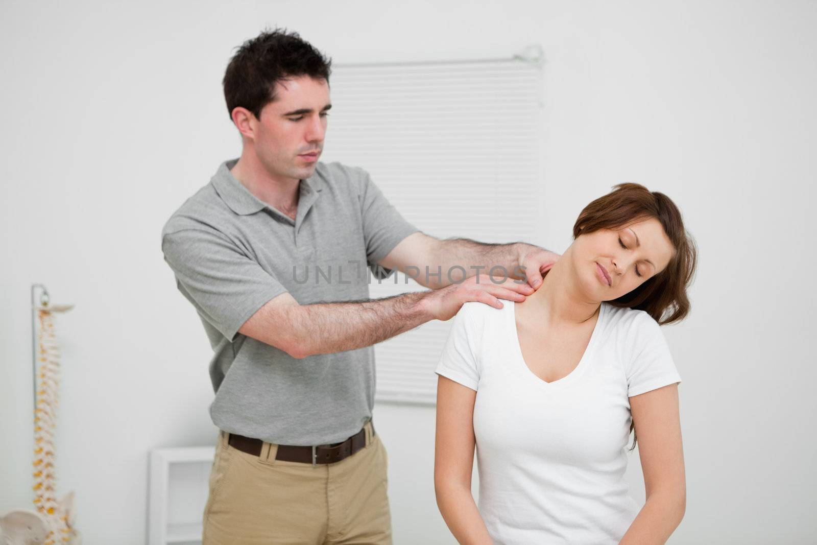 Practitioner looking at the neck of a patient in a medical room