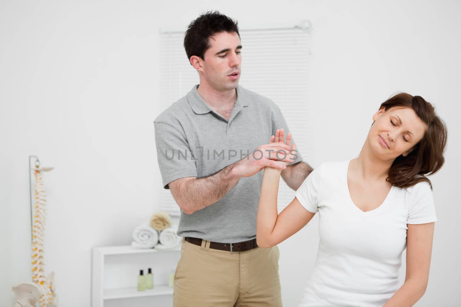 Peaceful woman being manipulated by a doctor in a medical room