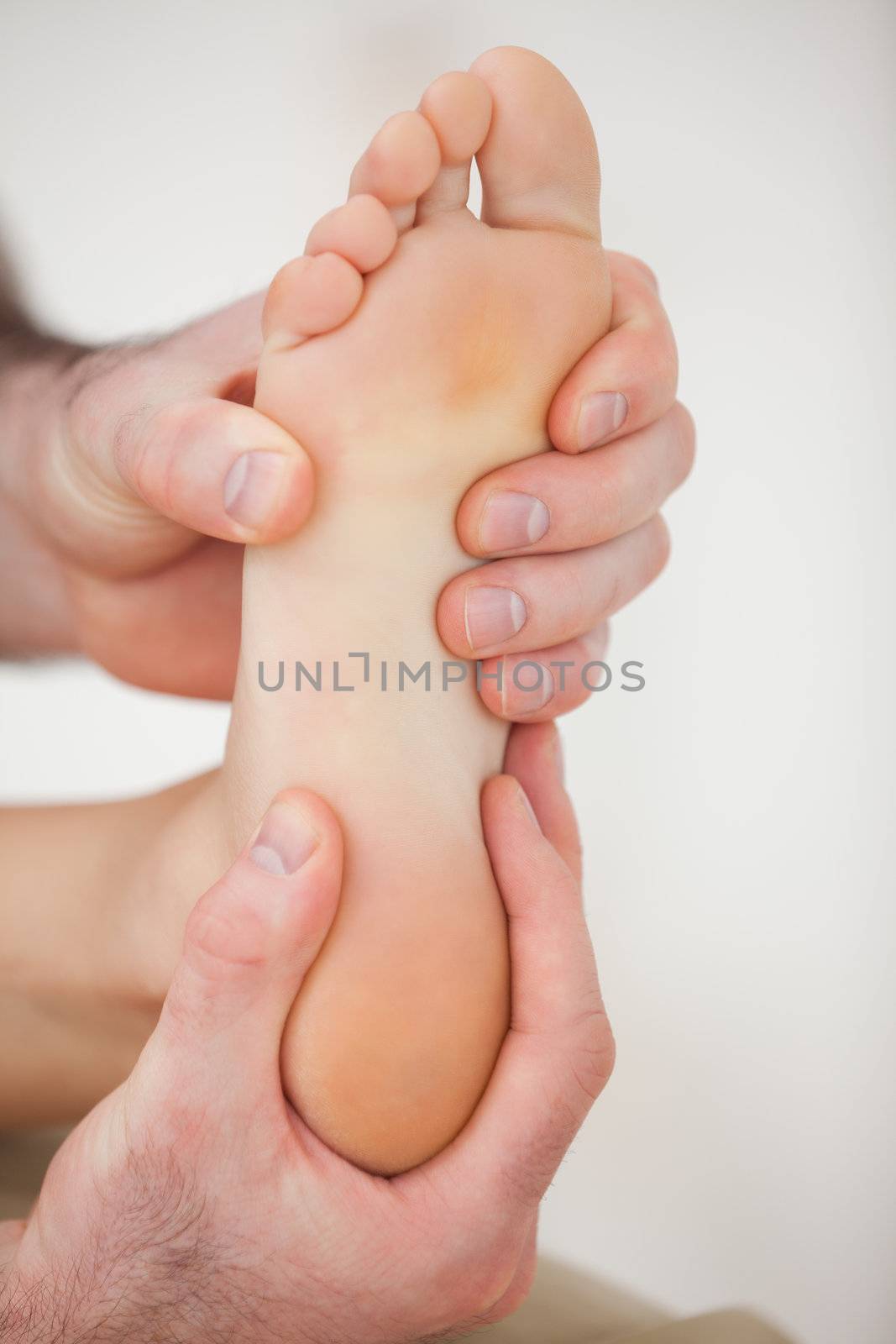 Physiotherapist working on a barefoot in a room