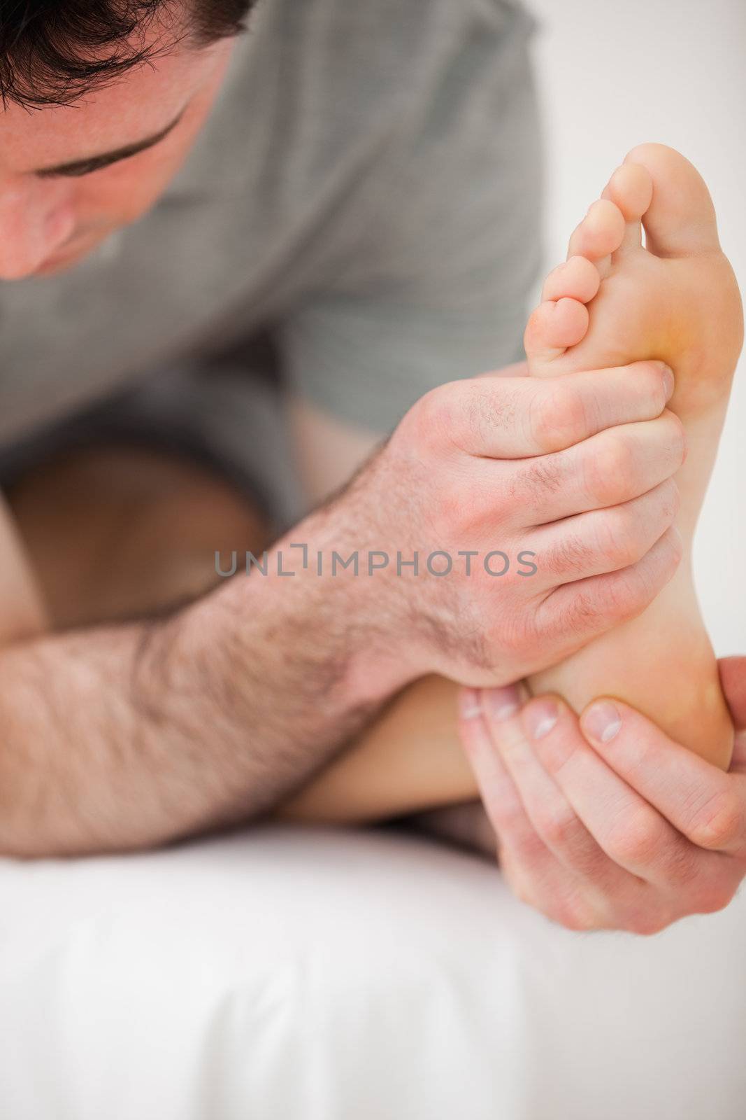 Serious physiotherapist making a joint mobilisation indoors