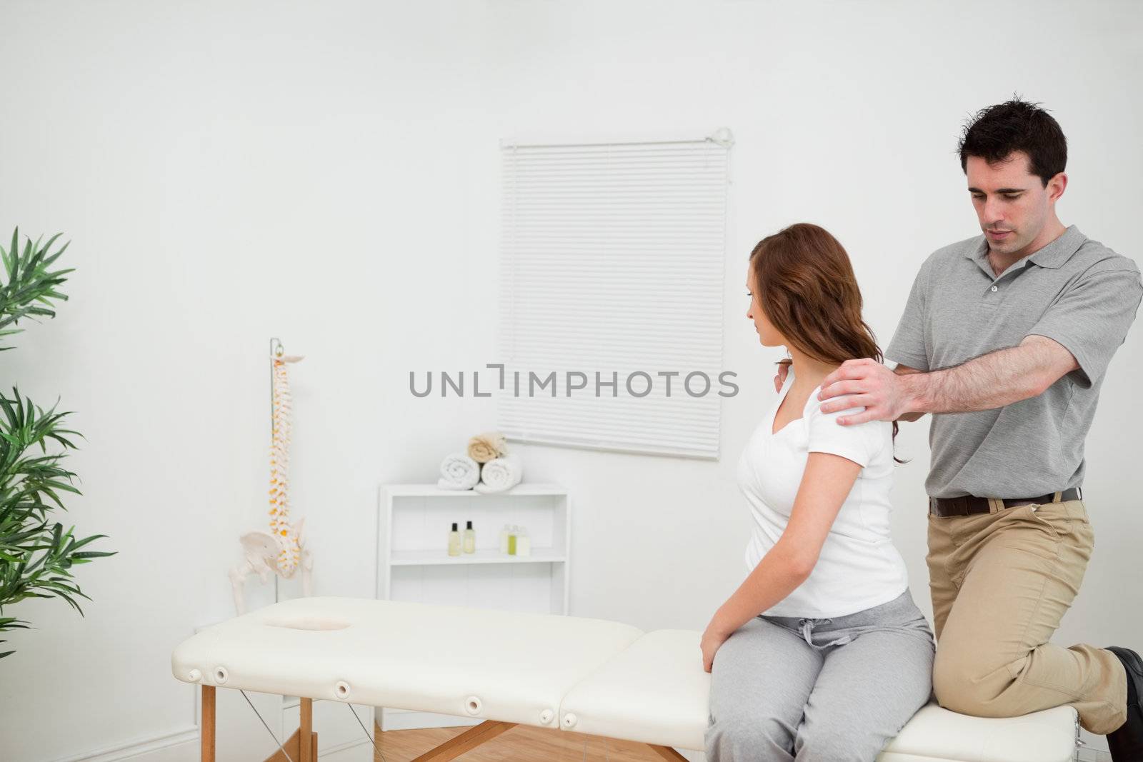 Osteopath looking at the back of a woman by Wavebreakmedia