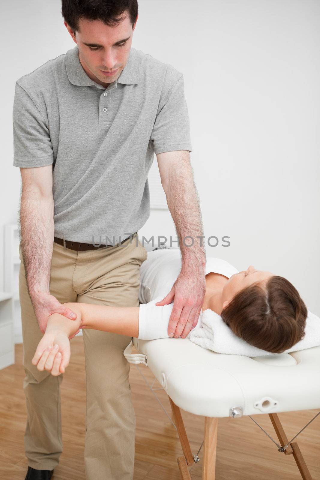 Serious practitioner holding the arm of a woman by Wavebreakmedia