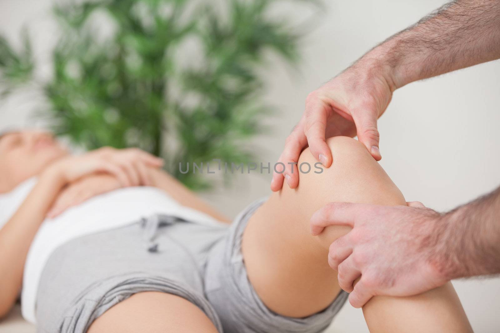 Practitioner using his fingers to massage a knee in a room