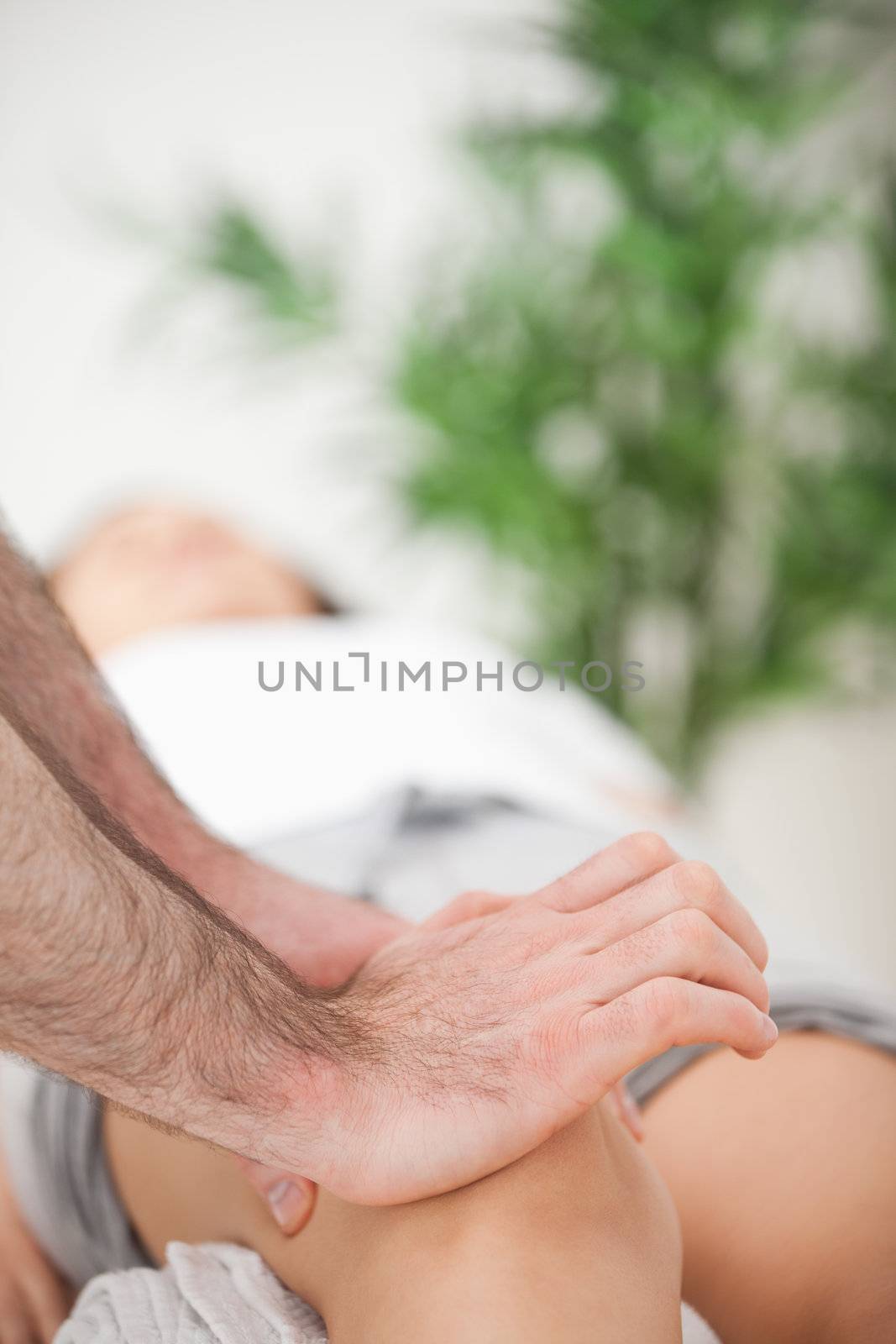 Serious doctor pressing on the knee of a woman by Wavebreakmedia