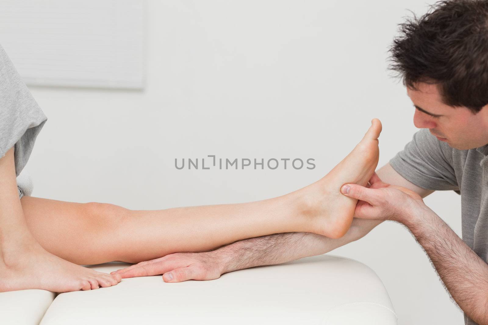 Physiotherapist looking at the foot of a patient in a room