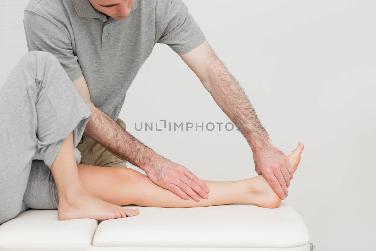 Calf of a patient being stretched by a doctor in a room