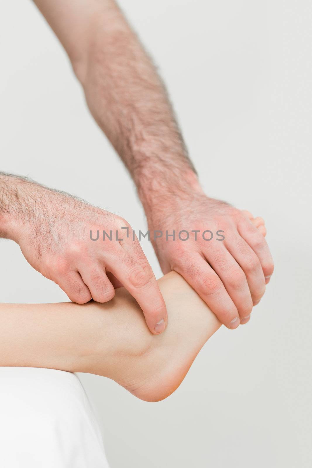 Physiotherapist touching the foot of a patient in a room