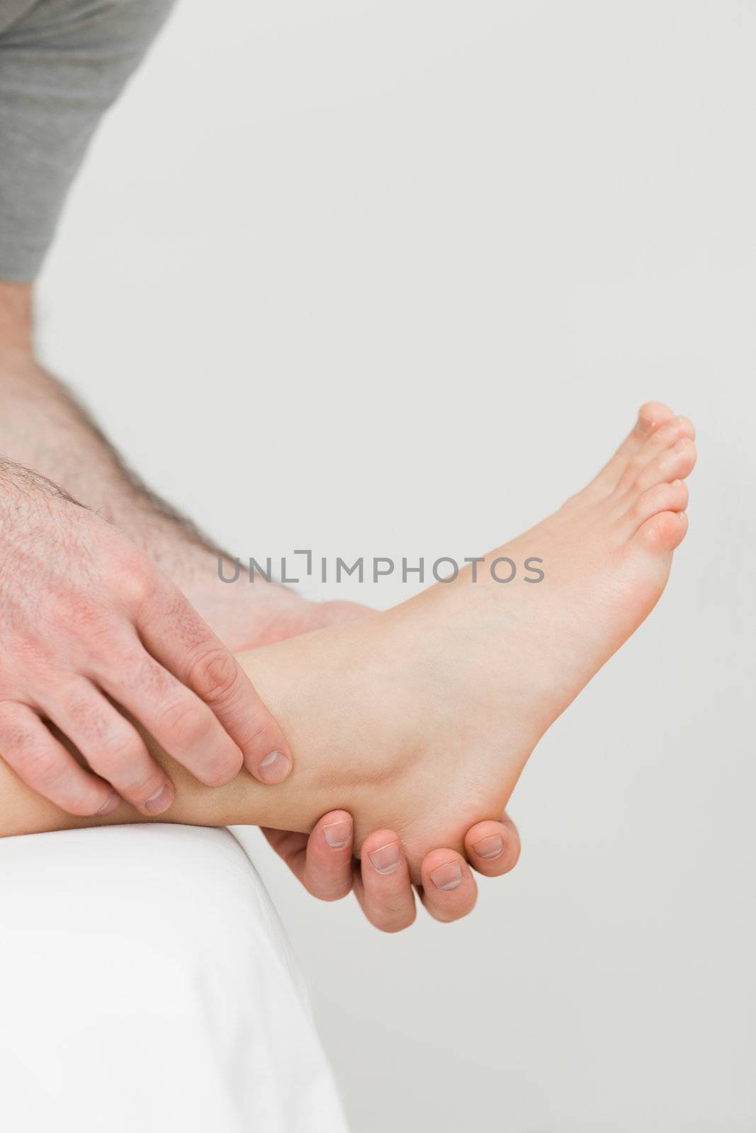 Ball of a foot being held by a practitioner in a room