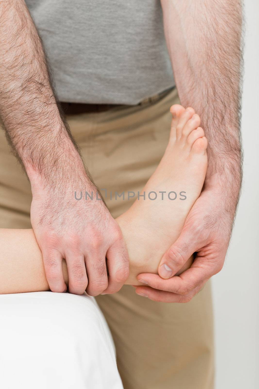 Foot being manipulated by a practitioner in a room