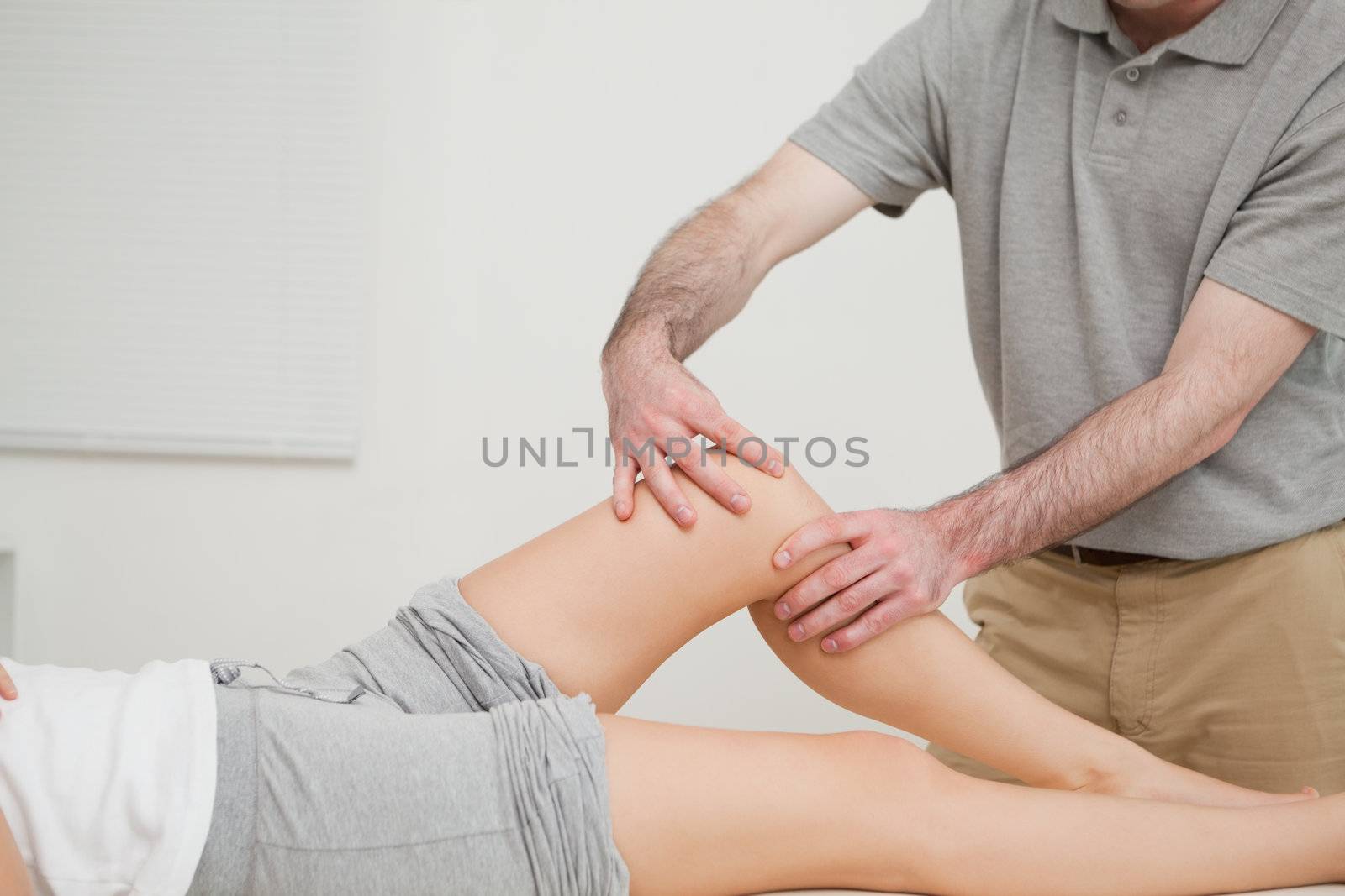 Knee of a woman being massaged by a physiotherapist in a room