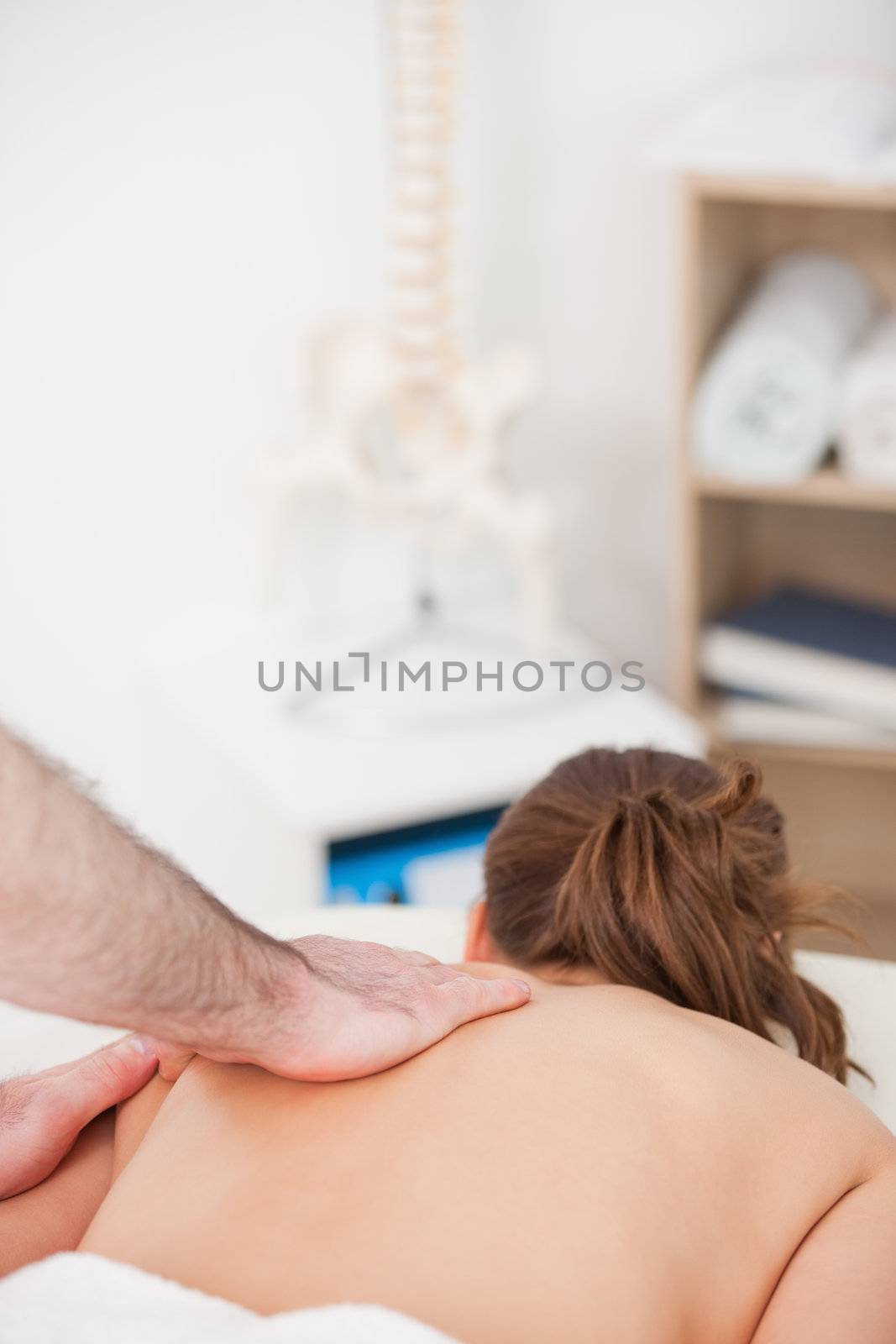 Woman being massaged while lying on the belly in a room