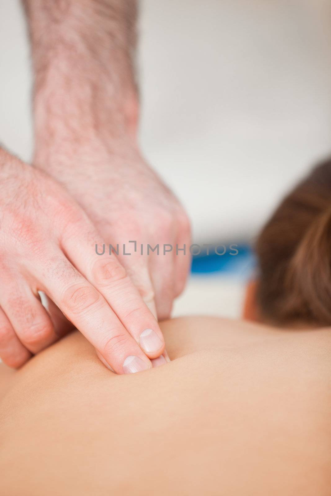 Doctor using his finger to massaged the back of his patient in a room