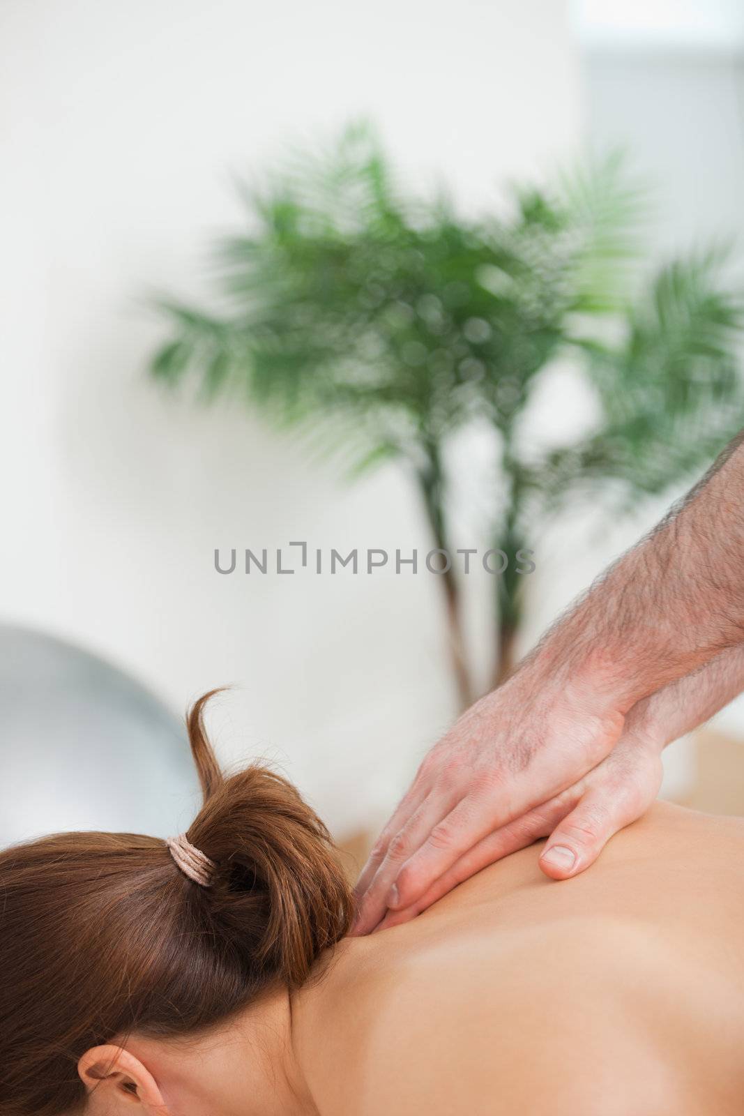 Practitioner massaging the top of back of his patient by Wavebreakmedia