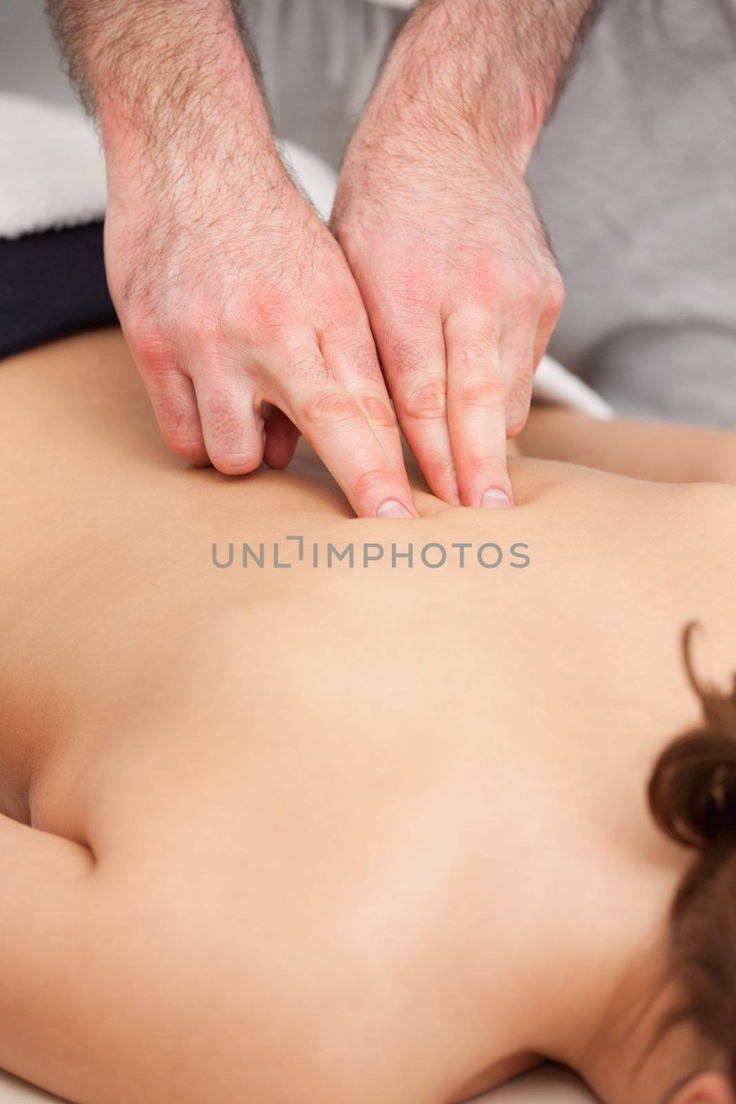Osteopath massaging a woman in the middle of her back in a room