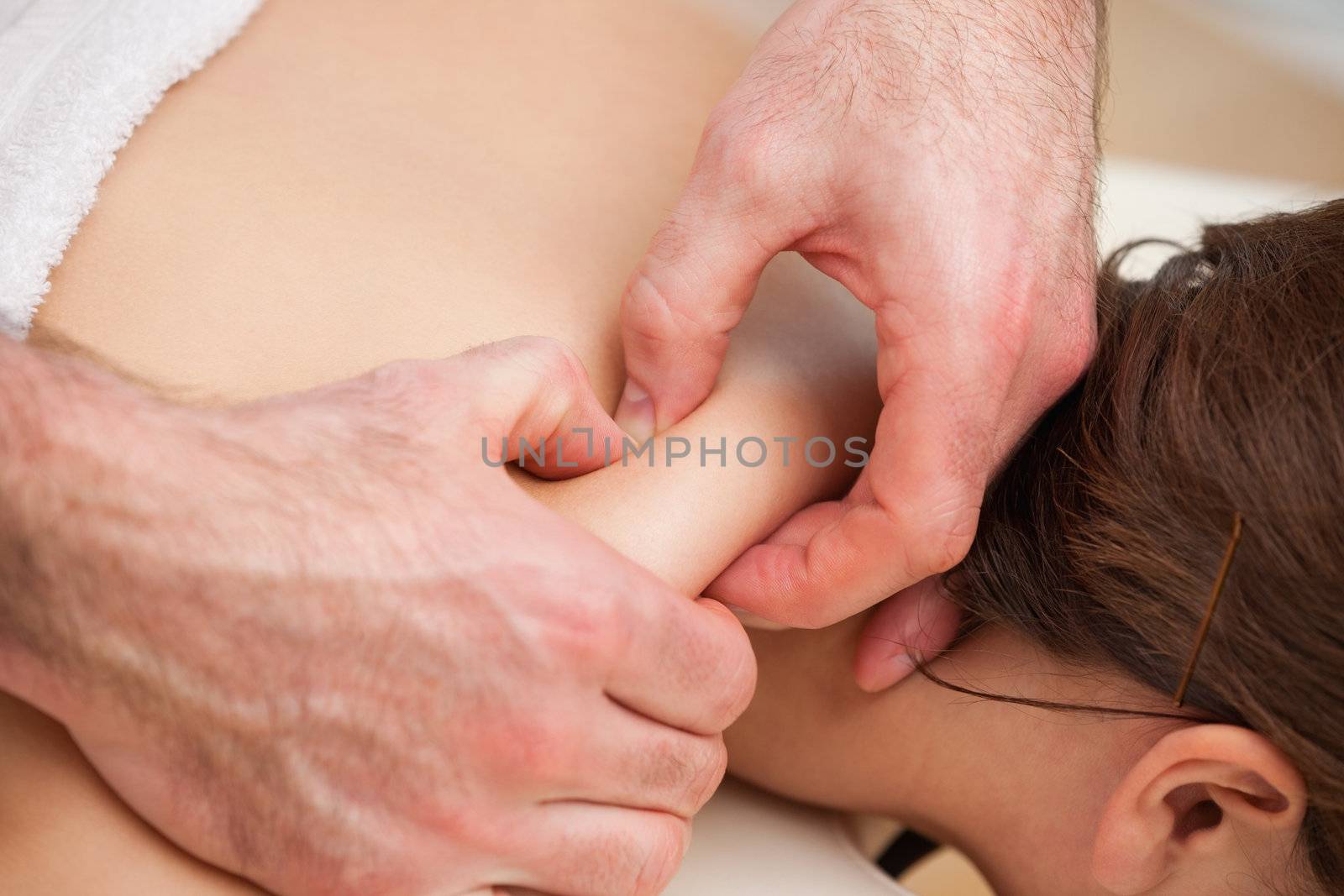 Back of woman being squeezed by hands of doctor in a room