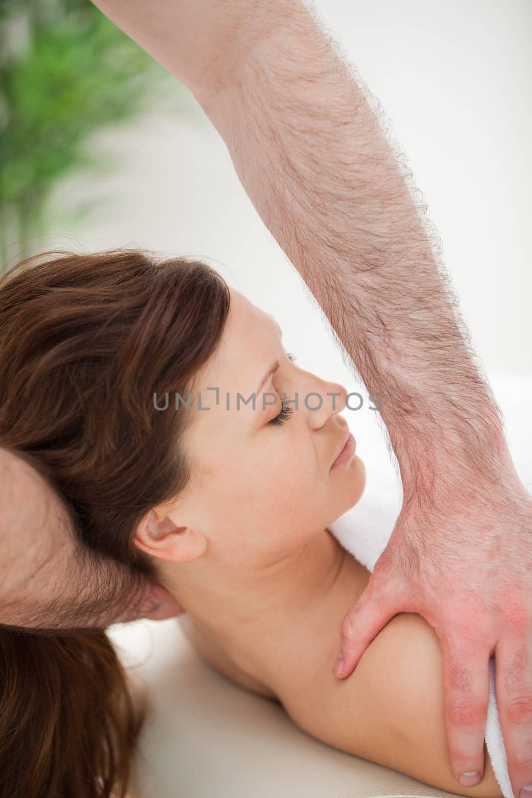 Therapist manipulating the neck of his patient while holding her by Wavebreakmedia