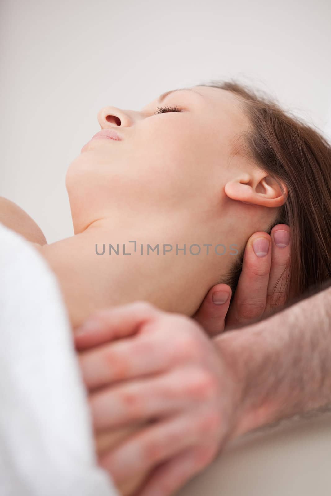 Close-up of neck of woman beig manipulating by a therapist in a room