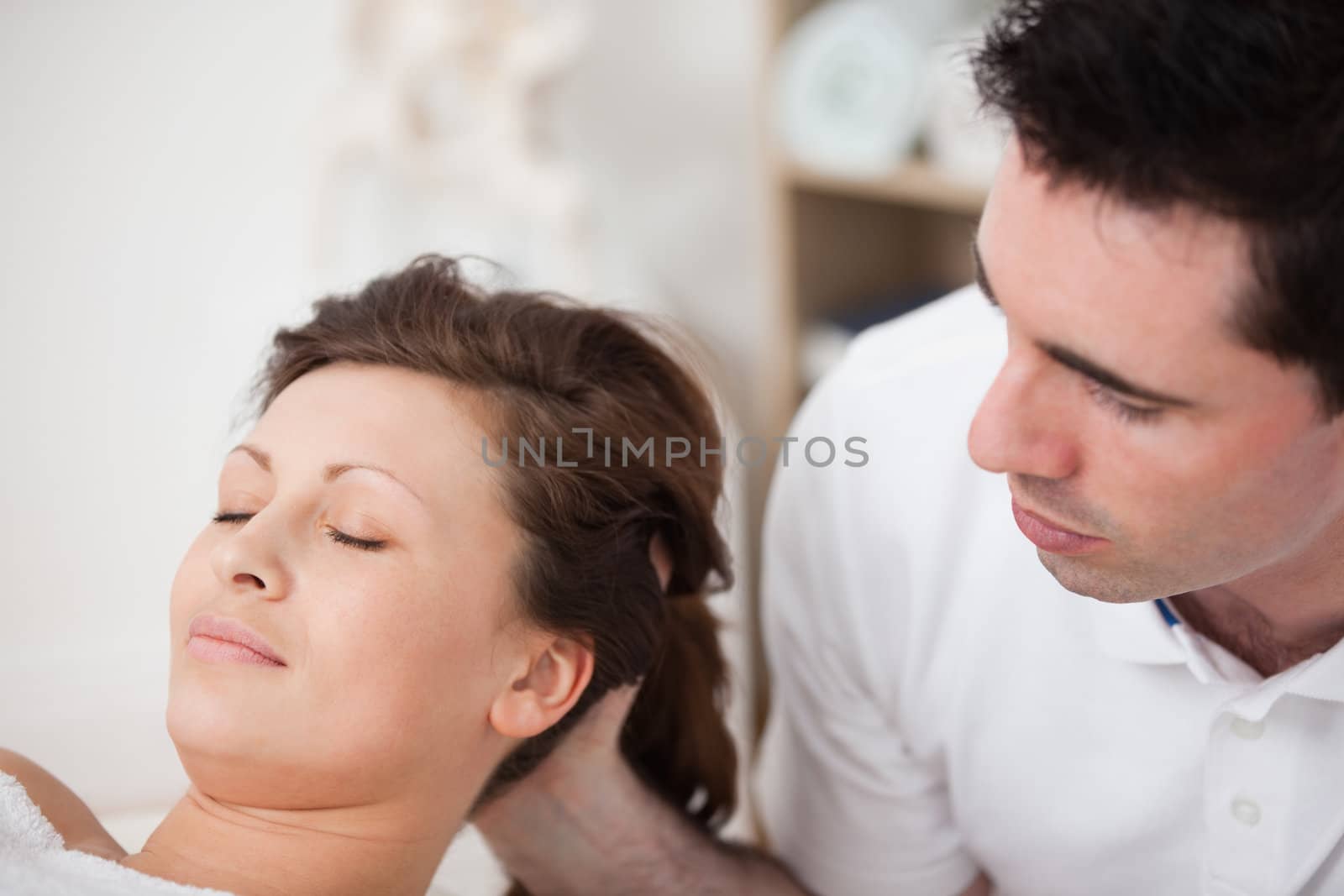 A doctor massaging the head of his patient while holding it by Wavebreakmedia