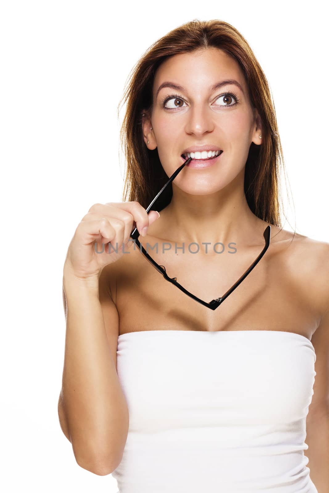 pretty woman bites on her glasses earpiece looking up on white background