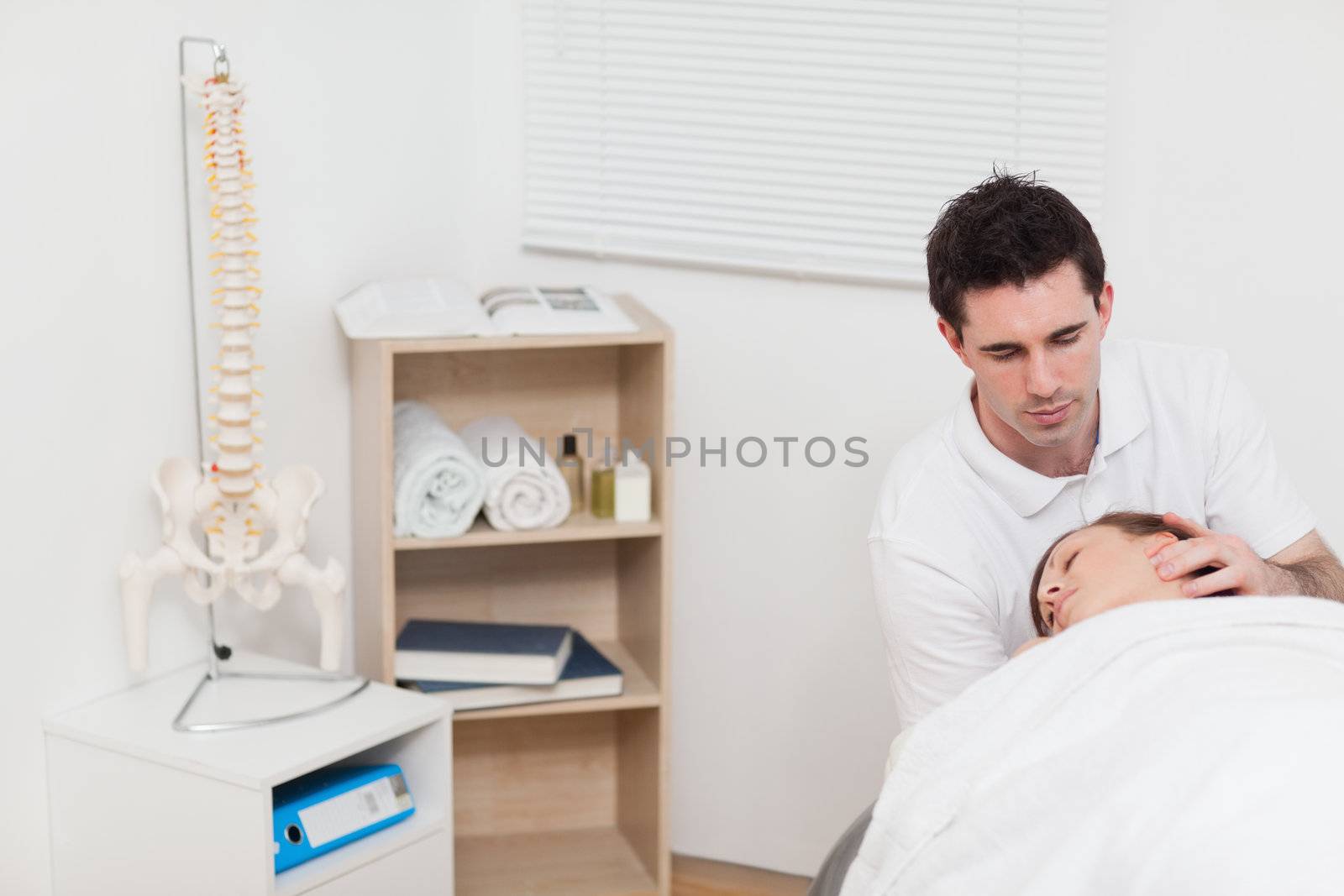 Neck of woman being manipulated by the chiropractor in a medical room