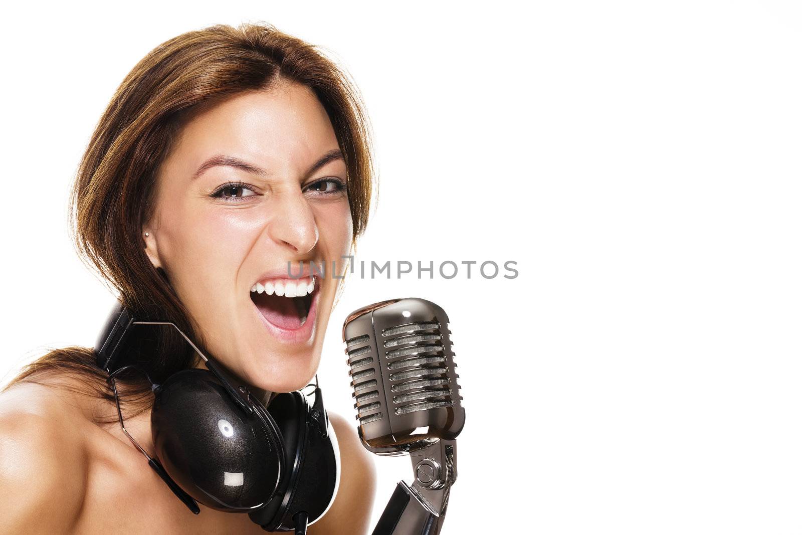 young female singer with headphones and a microphone on white background