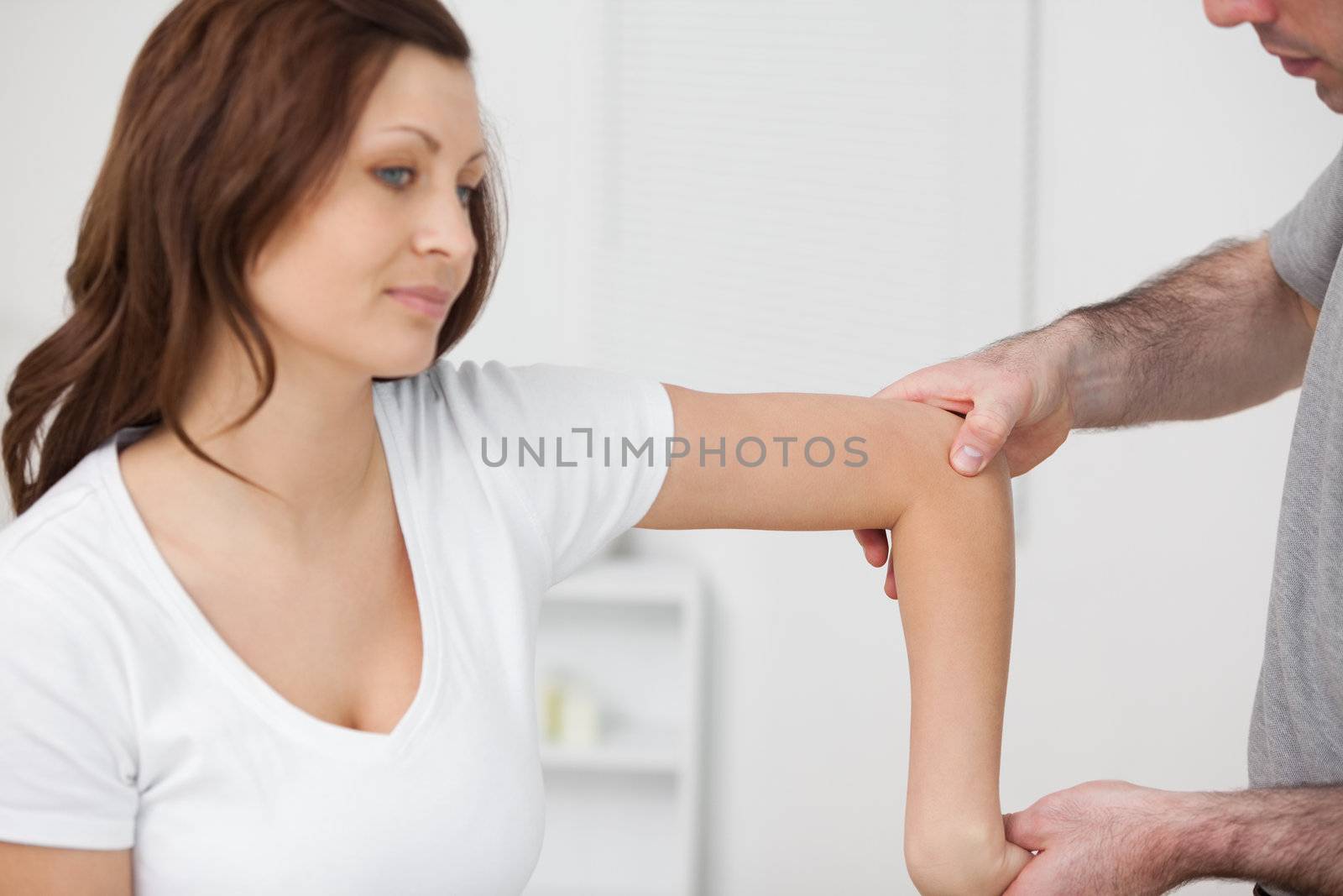 Doctor examining the arm of his patient by Wavebreakmedia
