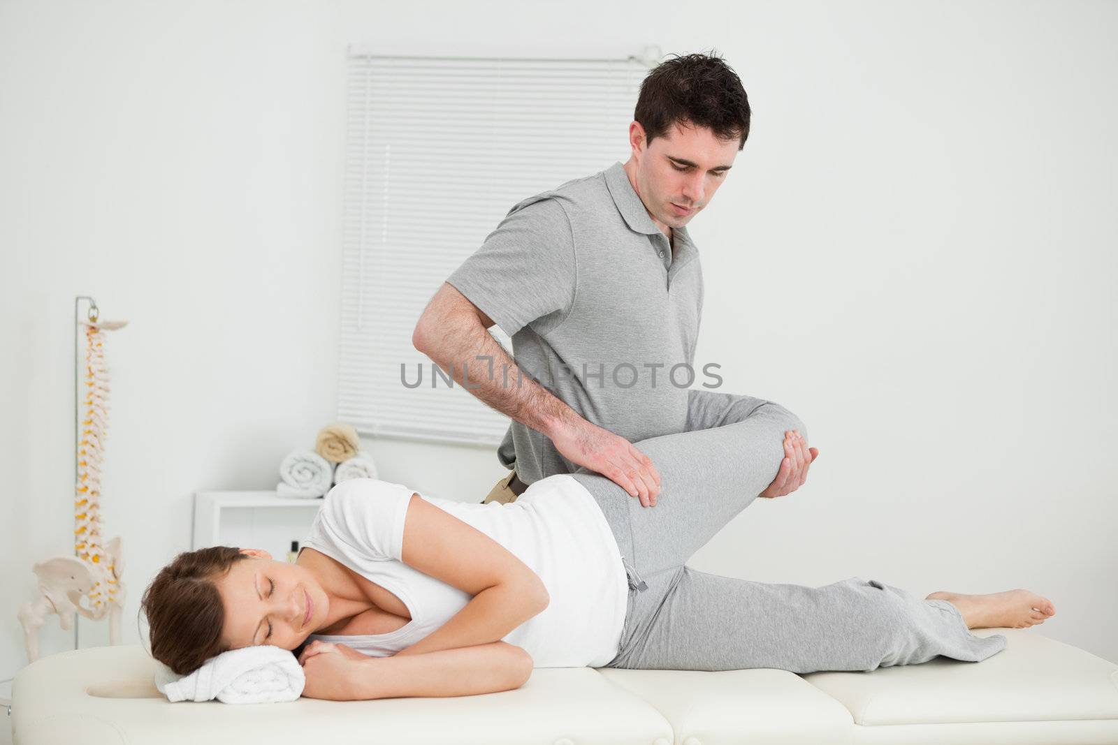 Leg of a woman being manipulated by a chiropractor in a medical room
