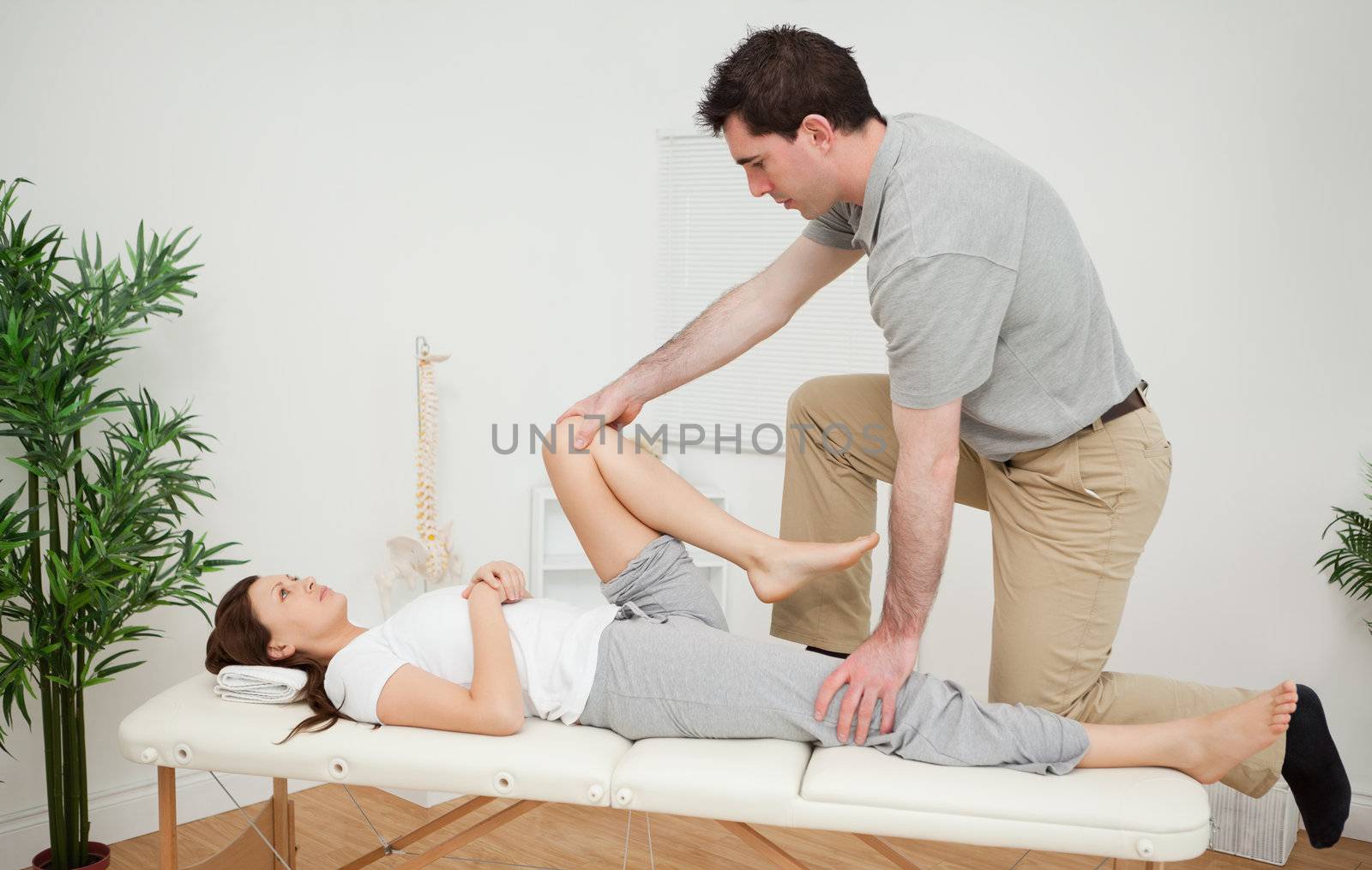 Woman being examining her leg by a chiropractor by Wavebreakmedia